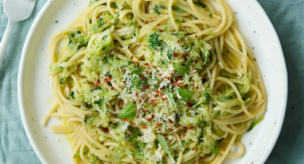 En tallrik spaghetti med riven zucchini, toppad med chiliflakes och riven ost.